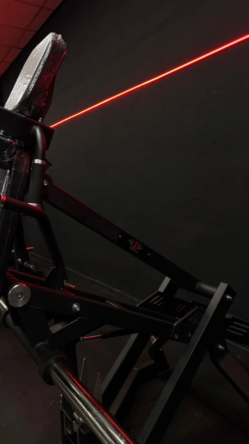 Máquina de fuerza junto a la línea de luz LED roja que recorre las paredes de JD Trainer